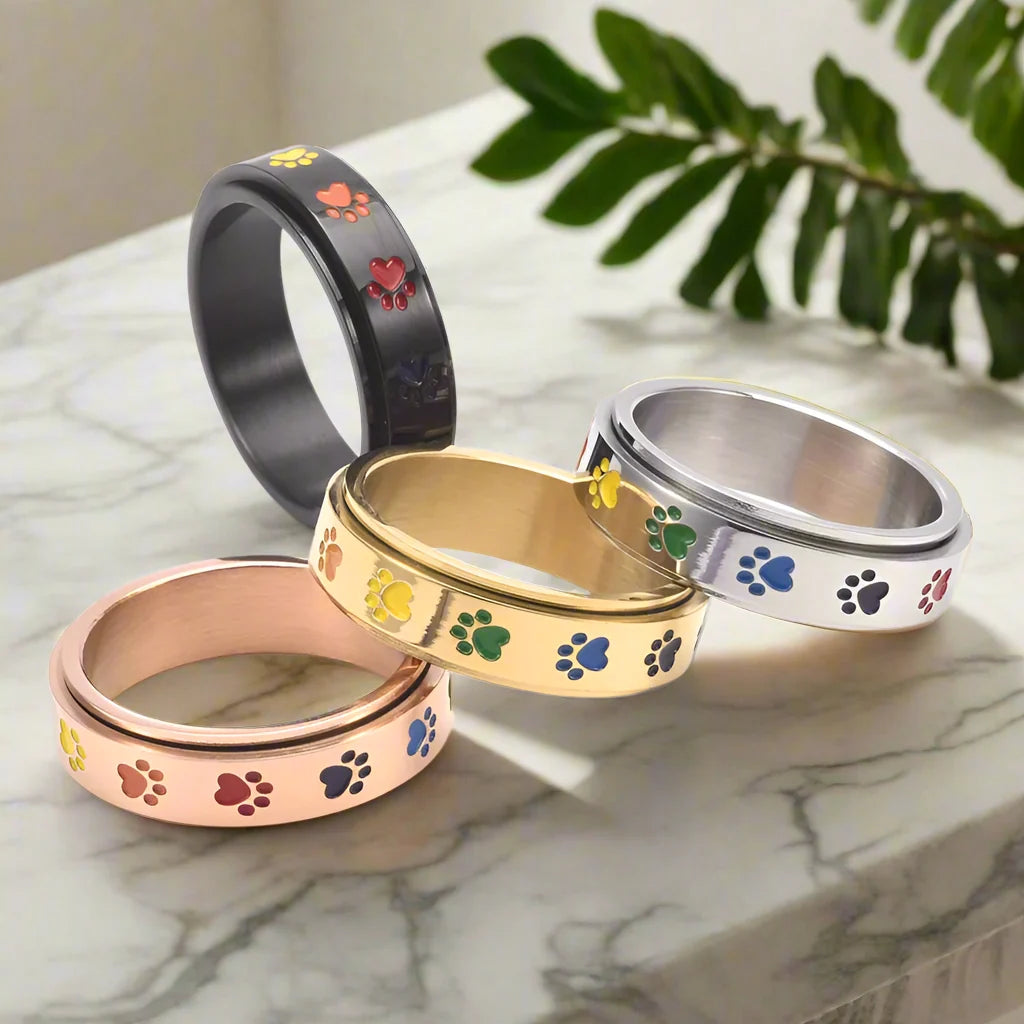 Snurrande antistressring med tassar – rostfritt stål med regnbågstassar