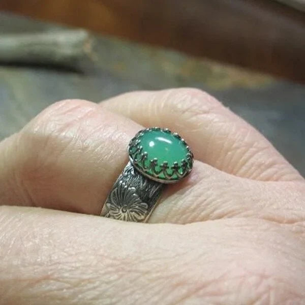 Ring med graverad blomma och smaragd